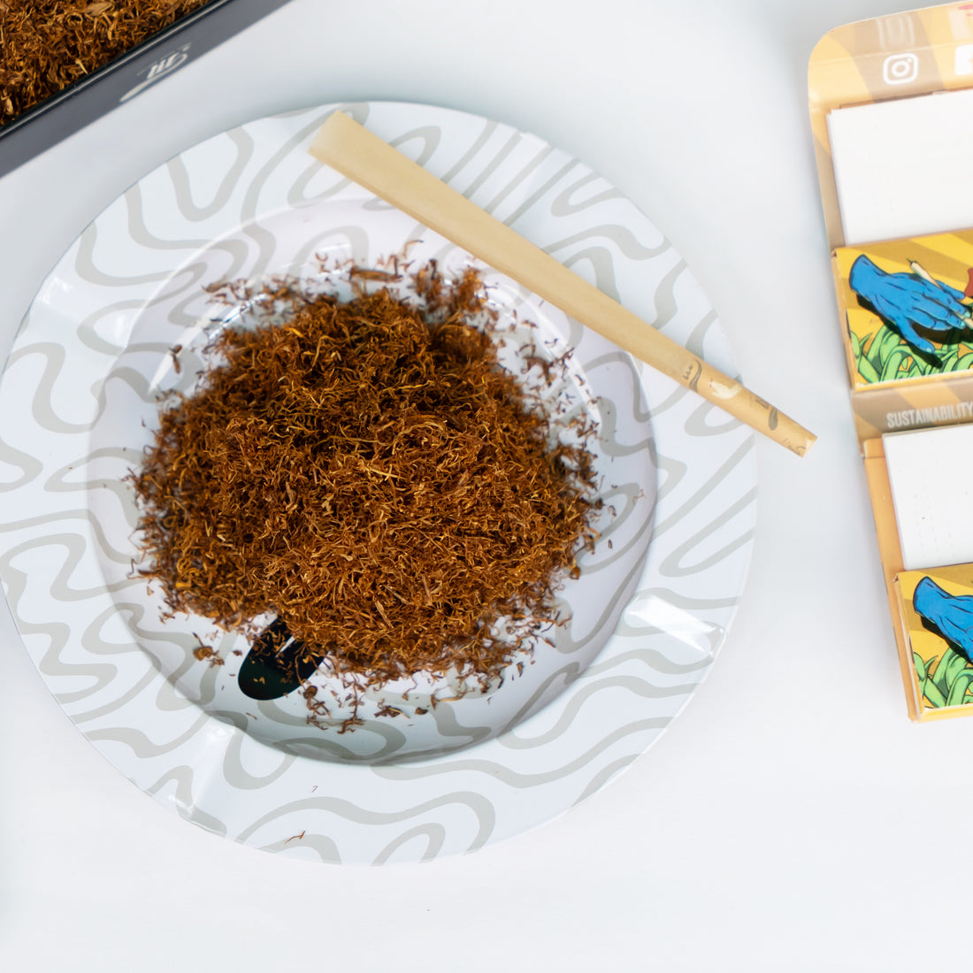 LIT Masala rolling tobacco loose cut displayed on a rolling tray with a hand-rolled cigarette
